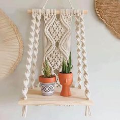 a macrame wall hanging next to a potted plant on a wooden shelf