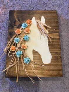 a horse head made out of flowers on a wooden board