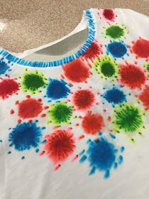 a white shirt with red, blue and green splats on it's chest