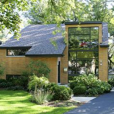 a brick house surrounded by lush green trees