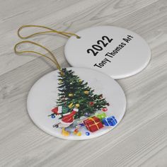 two personalized christmas ornament with a tree and presents on the bottom one