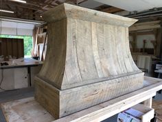 a wooden stove top sitting on top of a table in a room filled with boxes