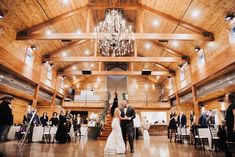 a bride and groom walking down the aisle at their wedding reception in an old barn