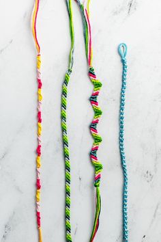 two colorful necklaces sitting on top of a marble counter