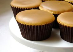 several cupcakes with frosting on a white plate