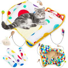 a cat laying on top of a colorful blanket next to other toys and gadgets