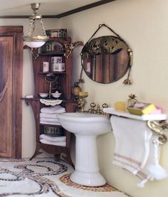 a bathroom with a pedestal sink, mirror and towel rack on the wall next to it