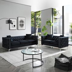 a living room filled with black couches next to a glass top coffee table in front of a large window