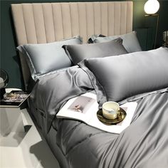 a bed that has some pillows on top of it and a cup next to it