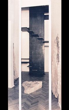 an empty room with some bookshelves on the floor and a stone block in the middle