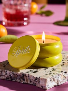 a yellow candle sitting on top of a table