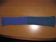 a knitted arm warmer sitting on top of a wooden table