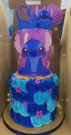 a blue and purple cake with an elephant on it's side in a cardboard box