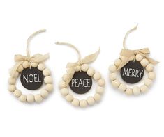 three wooden beads with words on them and a ribbon tied around the strings that says noel, merry