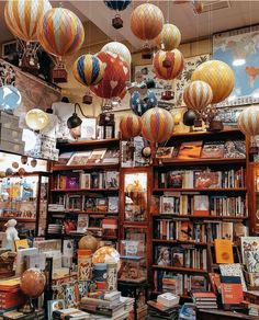 many bookshelves filled with lots of books and paper lanterns hanging from the ceiling