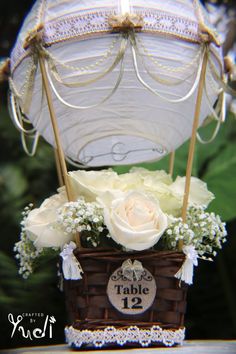 there is a basket with flowers and an umbrella in it that says table 12 on the side