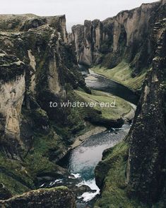 a river flowing through a lush green rocky hillside next to tall rocks and grass covered mountains