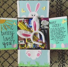 an open box filled with candy and some bunny ears on top of the inside is a card that says, some bunny loves you