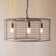 three lights are hanging from a wire cage chandelier in a room with white walls