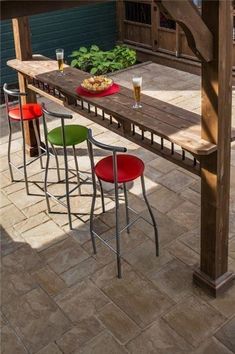 an outdoor table with four stools and some food on it