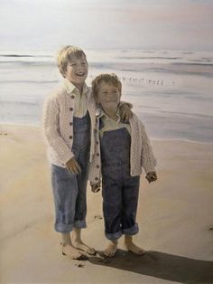 two young boys standing on the beach with their arms around each other