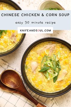 two bowls of chicken and corn soup on a table with spoons next to it