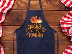 an apron with the words gobble til you wobble on it next to red and white checkered napkins