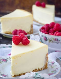 two slices of cheesecake with raspberries on the top and one slice missing