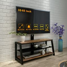 a flat screen tv sitting on top of a wooden stand in front of a brick wall