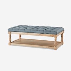 a wooden bench with blue upholstered cushion on it's top and bottom shelf