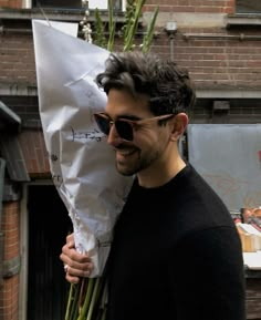 a man is holding a bunch of flowers