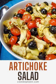 artichoke salad in a white bowl with olives and tomatoes