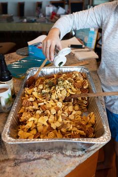 a woman is cutting up some food in a pan