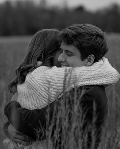 black and white photograph of couple hugging in tall grass