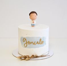 a white cake with a small figurine on top that says joncali