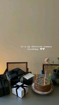 a birthday cake sitting on top of a table next to boxes with candles in them