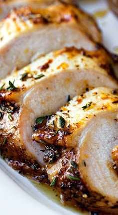 sliced pork with herbs and seasoning on a white plate