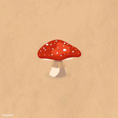 a red mushroom sitting on top of a wooden table next to a brown paper background