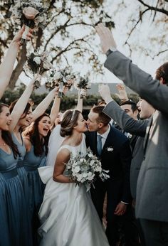 a bride and groom are surrounded by their wedding party