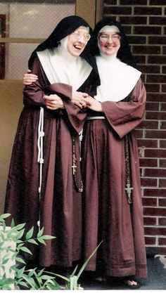 two women dressed in nun costumes standing next to each other on the front steps of a building