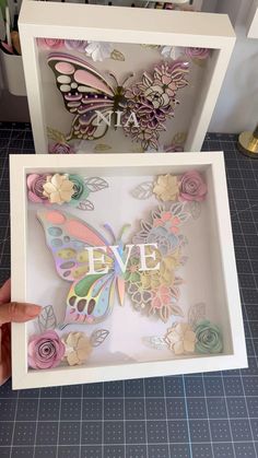 someone is holding up a paper butterfly in a box with the word eve on it