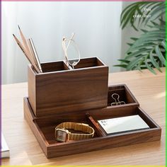 a wooden desk organizer with glasses, pen holder and notepad in it on a table