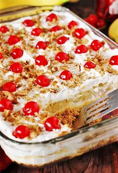 a close up of a cake in a pan with cherries on it and a fork