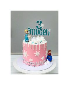 a frozen princess birthday cake with two figures on top and snowflakes around it