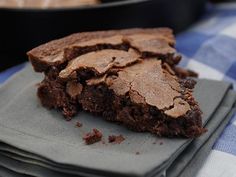 a piece of chocolate brownie sitting on top of a napkin