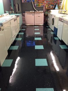 a kitchen with black and blue flooring next to washer and dryer machines