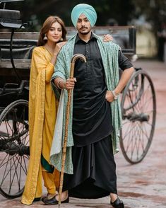 two people standing next to each other in front of a horse drawn carriage