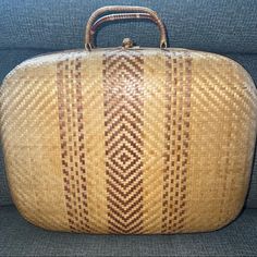 a woven suitcase sitting on top of a blue couch