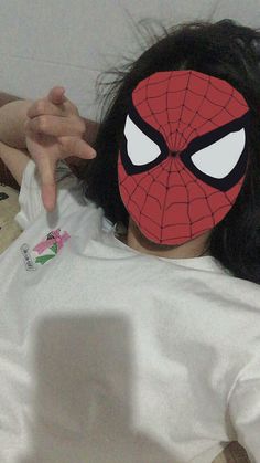 a person with a spiderman mask on laying down