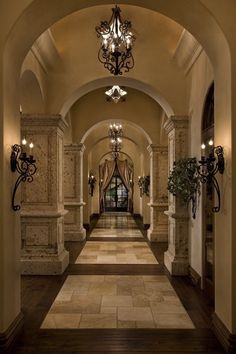 an elegant hallway with chandeliers and marble flooring is seen in this image